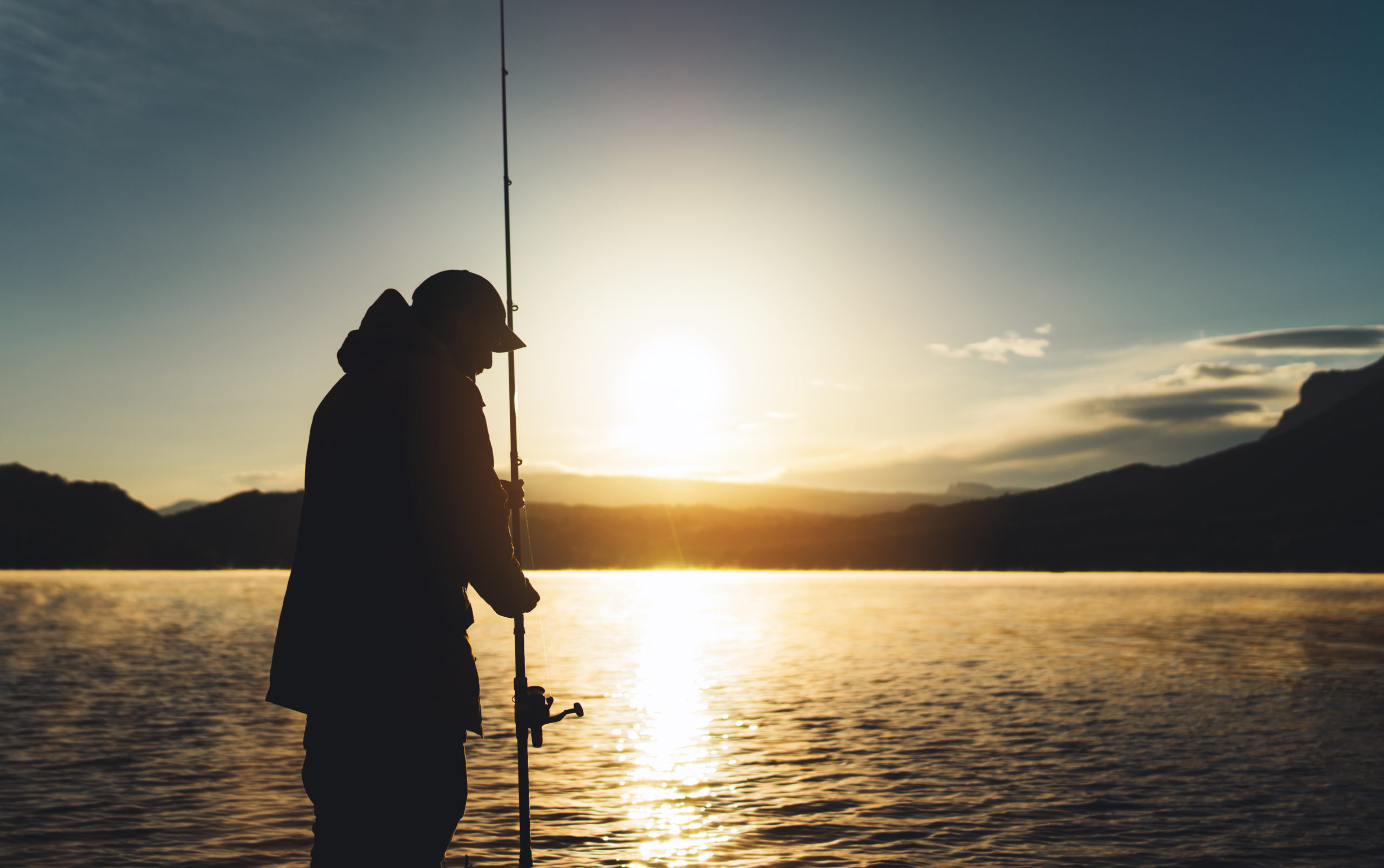 silhouette fisherman wirh fishing rod at sunrise sunlight, outli